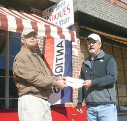 CEDC President Stephen Hall presents a check to Todd Knorpp for facade improvements to his buildings.
