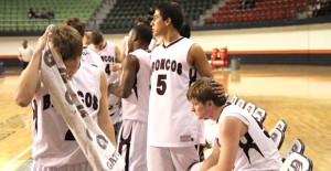 Senior starters for the Clarendon Broncos take their seats courtside as underclassmen players take the floor of the Texan Dome at South Plains College during the final seconds of the first round of the Regional Tournament last Friday night. Enterprise Photo / Roger Estlack