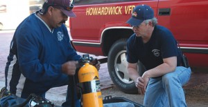 Clarendon Fireman Refugio Benavidez goes over some of the features of one of the SCBA devices with Howardwick Fire Chief Joe Hall, Sr., last Friday. Clarendon donated five older units to the Howardwick Fire Department after donations and a grant helped the buy new equipment.Enterprise Photo / Roger Estlack