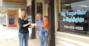 Clarendon EDC Executive Director Chandra Eggemeyer present a check to new Kearney Street shopkeeper Elaine Brownlee and Kelby Brownlee. Enterprise Photo / Roger Estlack