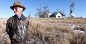 Mike Skinner holds a decades-old aerial photograph of the land near Spearman that three generations of his family had farmed. Texas Tribune Photo / Stephen Spillman