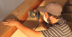 Jake Daughtery of Pioneer General Contractors in Amarillo sands woodwork in the lobby of the Mulkey Theatre Tuesday morning as part of Phase Two interior renovations to the building. Workers are focused on refinishing the lobby, restrooms, concession area, and ticket booth for this phase. The Clarendon Economic Development Corporation will unveil the progress on the project at the second annual Mulkey Block Party on Saturday, May 24.  Enterprise Photo / Roger Estlack