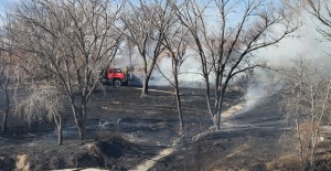 A Clarendon fire truck puts out hot spots west of the Country Club in Howardwick last Friday after a grassfire threatened several homes. Enterprise Photo / Roger Estlack