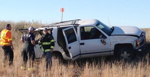 Emergency personnel look over the wreck of a single-vehicle accident east of Clarendon Sunday afternoon. Enterprise Photo
