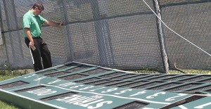 Clarendon College Athletic Director Brad Vanden Boogaard surveys the remains of the Lady Bulldogs softball scoreboard after a high wind gust Monday evening tore the sign from its posts and dropped it in the outfield. The top of the sign was thrown about 50 yards away from the field.  Enterprise Photo/Roger Estlack