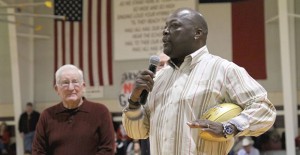 Former Clarendon High School coach Jeff Walker watches as Super Bowl legend Kenny King addresses the crowd at the Bronco Gym last Friday night during the presentation of a golden football to the community from the NFL as part of the celebration leading up to Super Bowl 50. Enterprise Photos / Ashlee Estlack