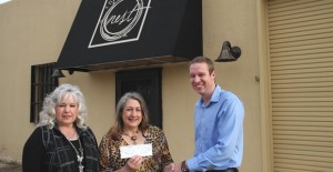 Theresa Shelton and Chriss Clifford receive a $2,000 check from Clarendon EDC board member Jacob Fangman for improvement’s to their property at 311 E. Second Street. Enterprise Photo / Roger Estlack