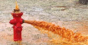 Red water flushes from a fire hydrant near the Saints’ Roost Museum as an example of discoloration caused by old cast iron distribution water lines, according to city officials. A Town Hall meeting will be held March 29 to discuss a .9 million proposal to address issues such as this. For a map of the proposed project, see page ten. Courtesy Photo / City of Clarendon