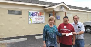 CEDC President Terri Floyd awards a check for $2,000 to Steve Carter of Christ’s Kids Ministries for façade improvements. Also pictured here is Jakoby Dunham, a Christ’s Kids volunteer. Enterprise Photo / Roger Estlack