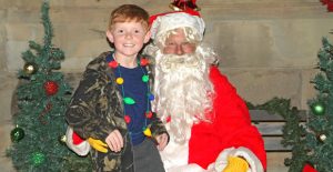 Mason Green visits with Santa Claus about what he wants for Christmas before the lighting of the Courthouse last Saturday. Enterprise Photo / Roger Estlack