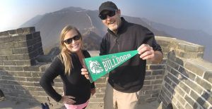 Nik and Dusty Green, stars of the new PBS series “Two for the Road” with a Clarendon College pennant on top of the Great Wall of China. Courtesy Photo / Dusty & NIkki Green