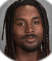 Portrait of a man with long dreadlocks looking at the camera.